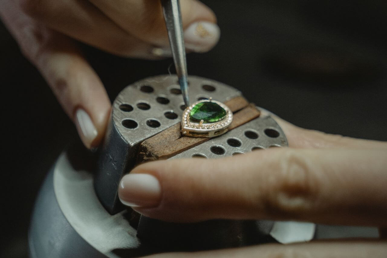 Žena pravi nakit sa smaragdom.